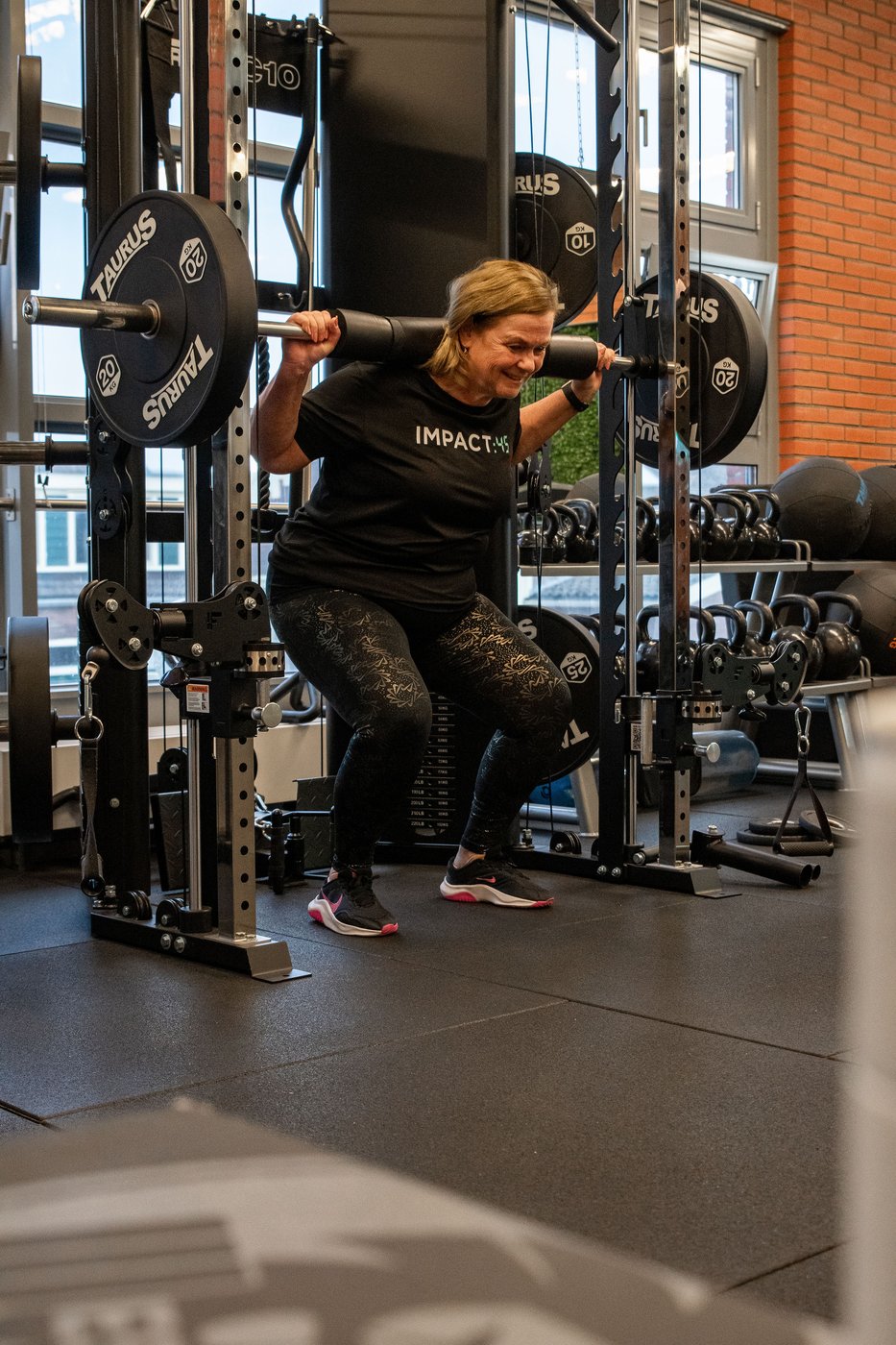 Lid doet squats in de squatrack bij Impact:45